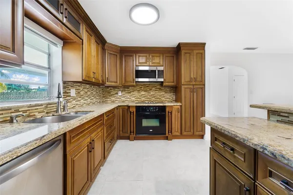 a kitchen with granite countertop a sink and a stove top oven