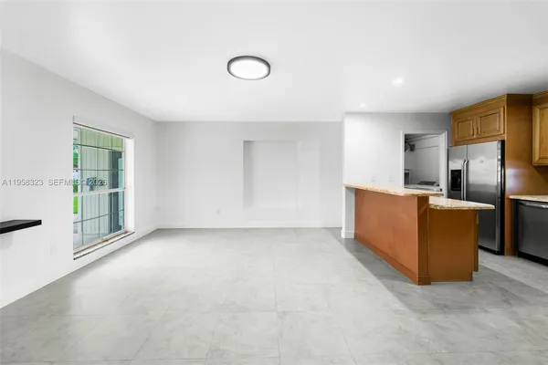 a view of a kitchen with refrigerator and windows