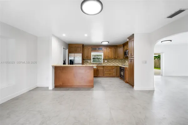a large kitchen with a large counter top stainless steel appliances and cabinets