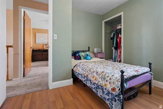 165 Pheasantbrook Drive Centerville, UT 84014 - Photo 17 of 30 Bedroom featuring a closet, a textured ceiling, and light wood-style floors