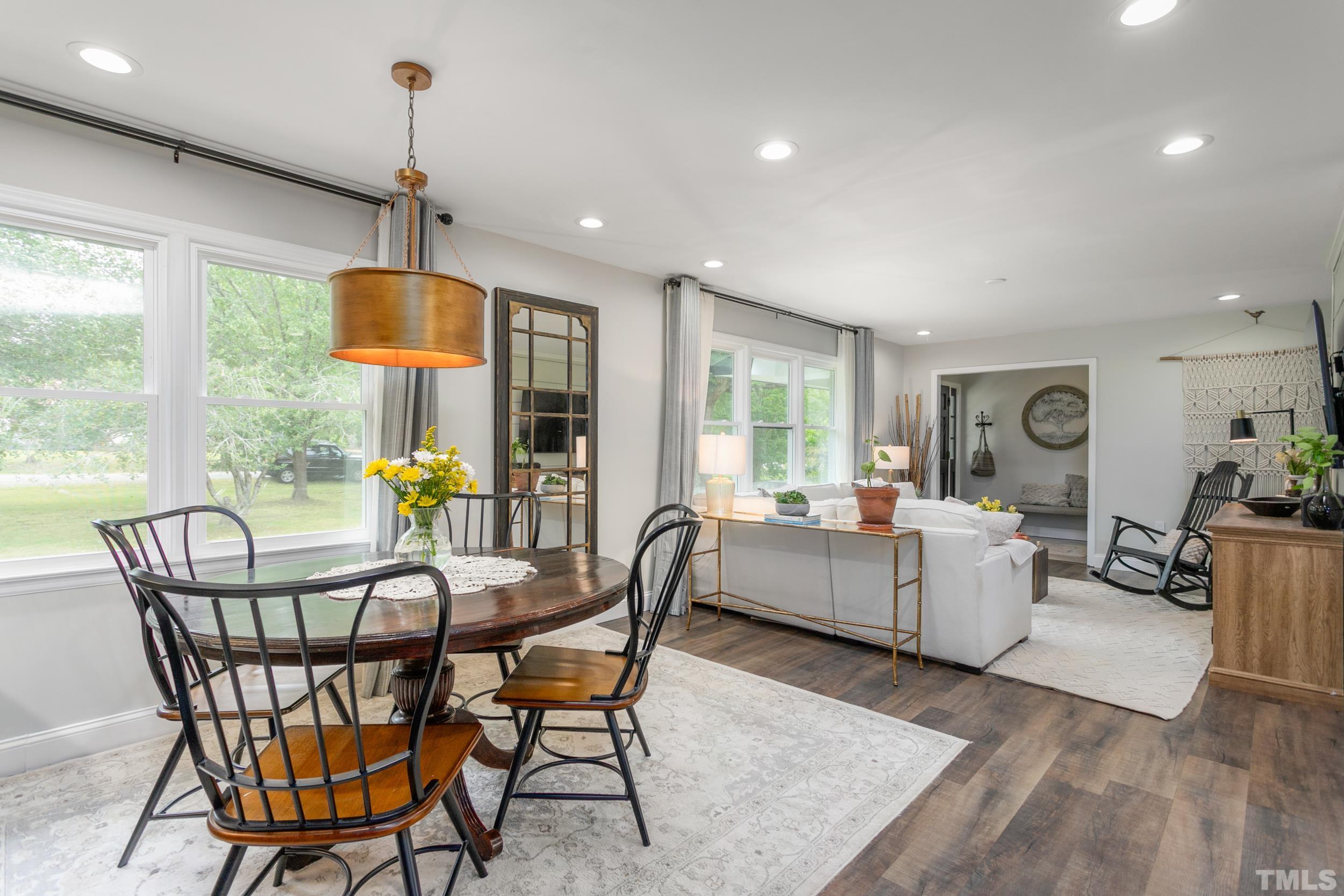 238 Alston Road Apex, NC 27523 - Photo 11 of 50 a dining room with furniture a chandelier and wooden floor