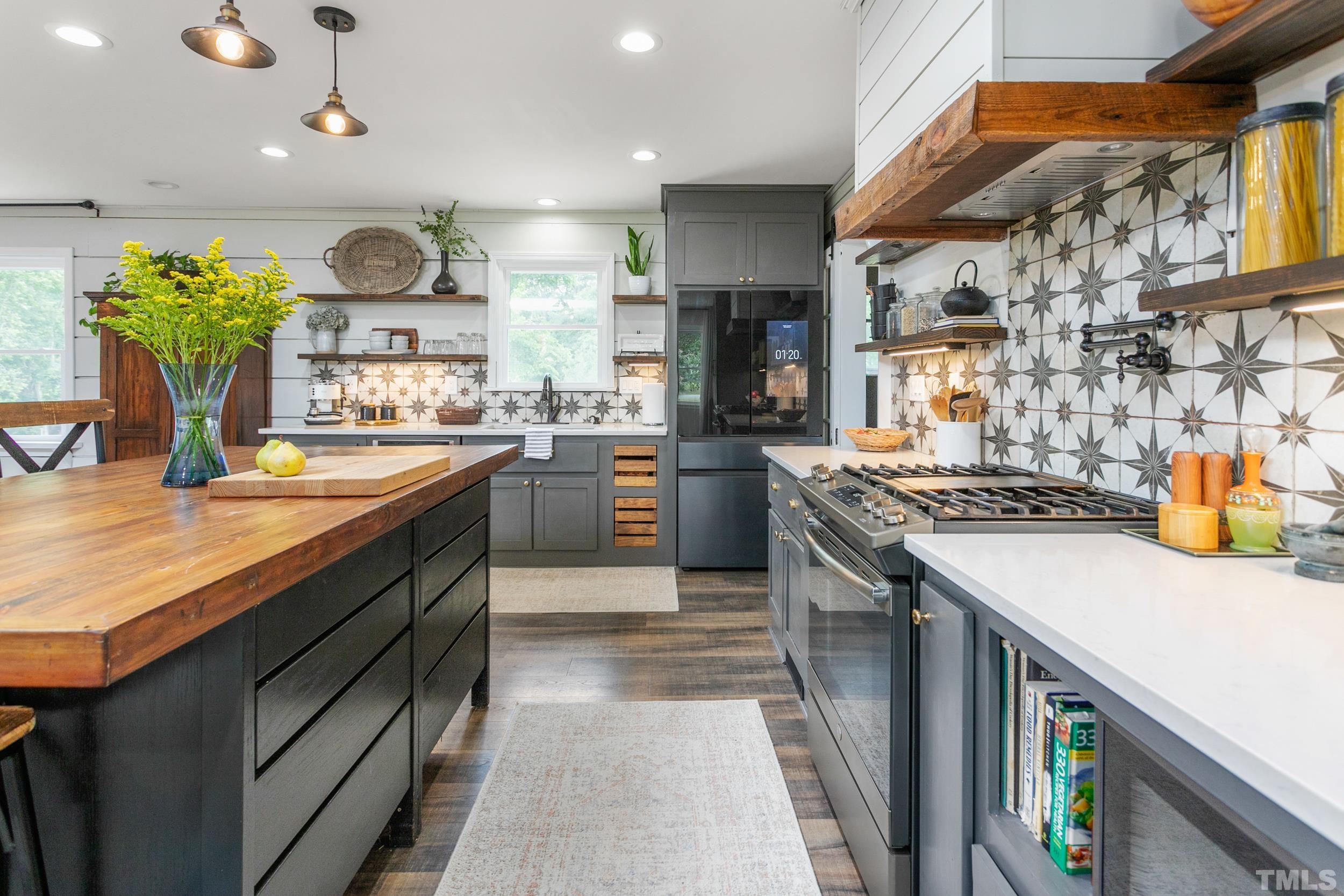 238 Alston Road Apex, NC 27523 - Photo 17 of 50 a kitchen with stainless steel appliances granite countertop a sink a stove and a wooden floors