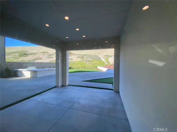 a view of hallway with a large window and sitting space