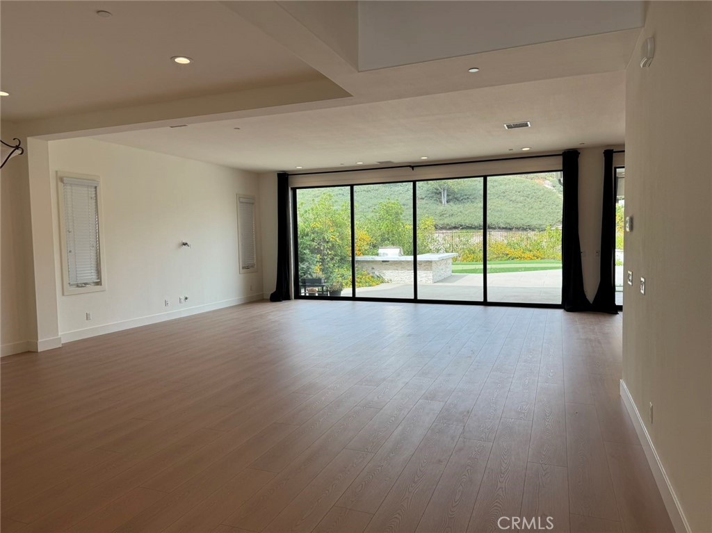 101 Interstellar Irvine, CA 92618 - Photo 3 of 24 a view of an empty room with a large window and wooden floor