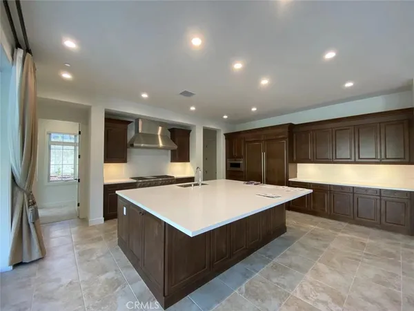 a large kitchen with kitchen island a sink stainless steel appliances and cabinets