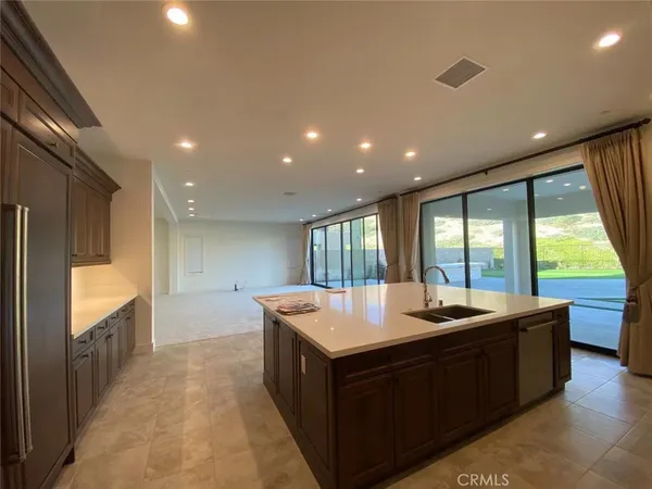 a large kitchen with kitchen island a large window in it