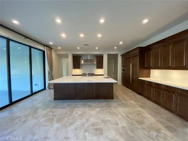 a large kitchen with kitchen island a sink stainless steel appliances and cabinets