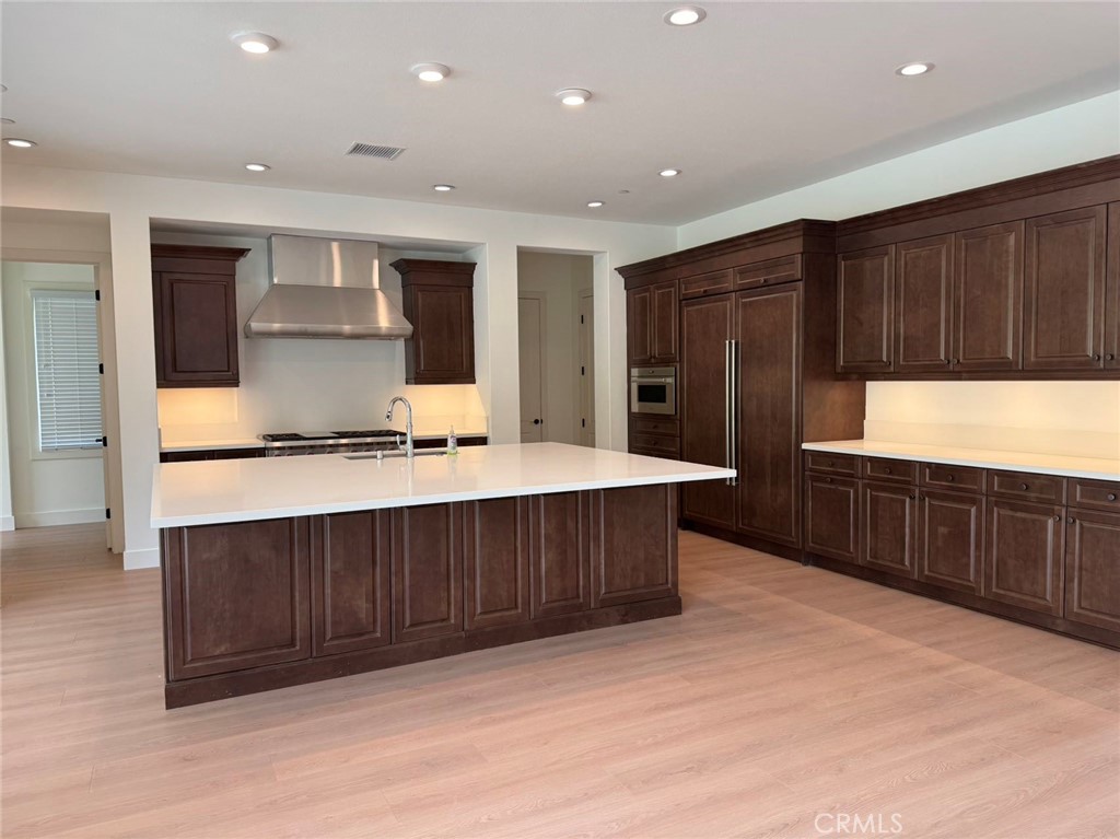 101 Interstellar Irvine, CA 92618 - Photo 9 of 24 a kitchen with kitchen island granite countertop wooden cabinets and white stainless steel appliances