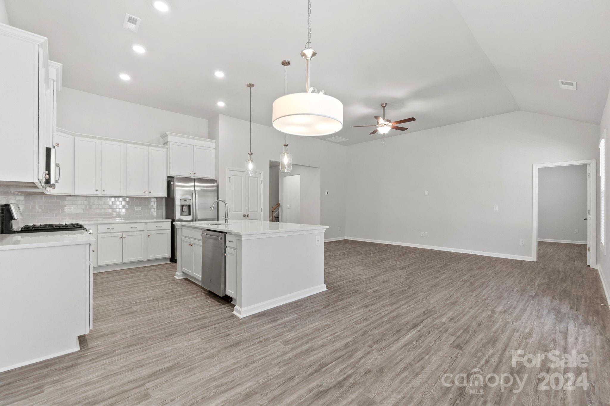 8204 Mccormick Street Terrell, NC 28682 - Photo 17 of 32 a kitchen with stainless steel appliances granite countertop a sink cabinets and wooden floor