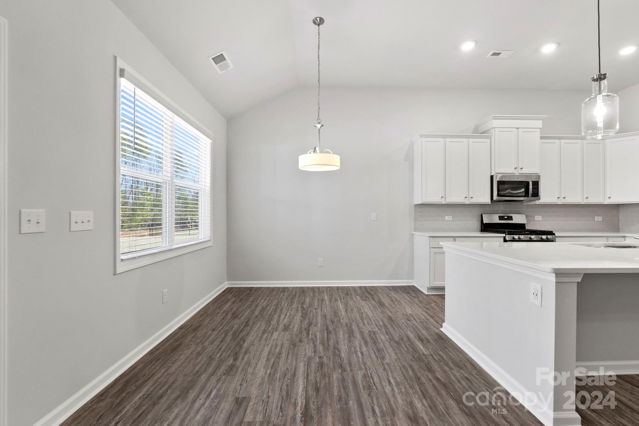 8204 Mccormick Street Terrell, NC 28682 - Photo 18 of 32 a kitchen with cabinets a window and stainless steel appliances