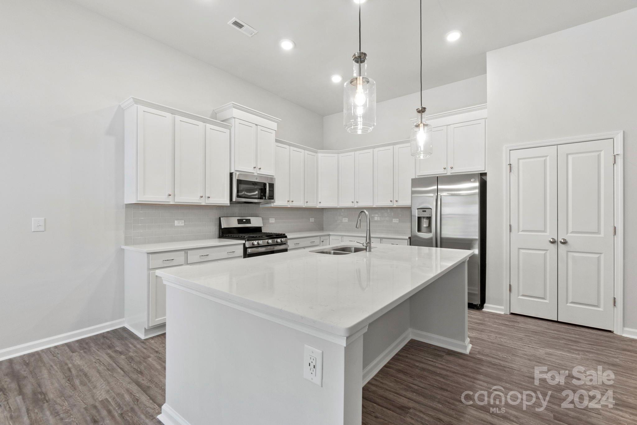 8204 Mccormick Street Terrell, NC 28682 - Photo 19 of 32 a kitchen with a sink a stove a refrigerator and white cabinets