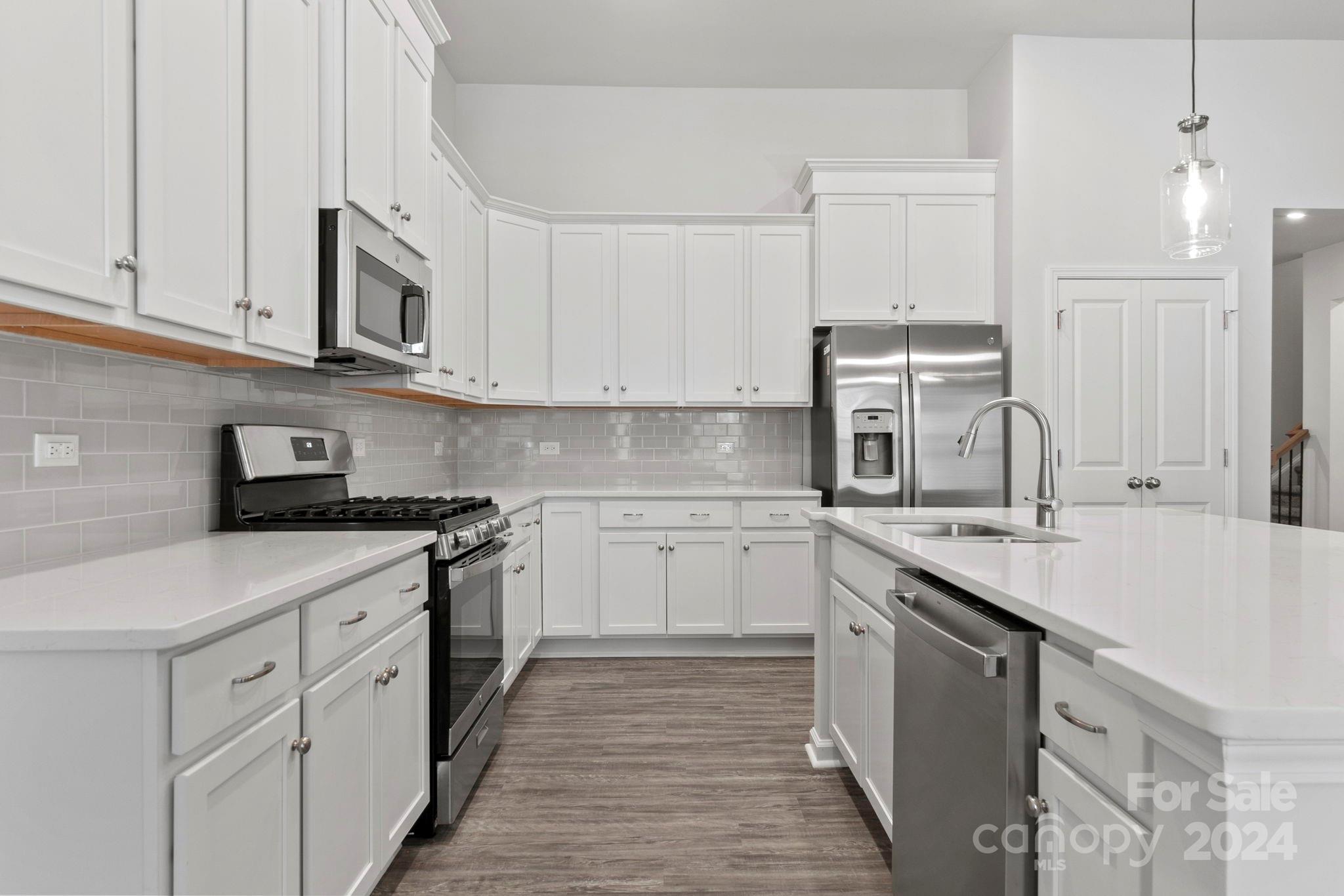 8204 Mccormick Street Terrell, NC 28682 - Photo 20 of 32 a kitchen with stainless steel appliances granite countertop a sink and dishwasher a stove top oven with white countertops