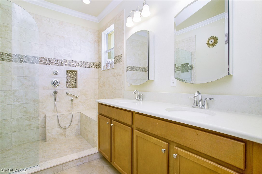 7948 Princeton Drive Naples, FL 34104 - Photo 15 of 35 a bathroom with a granite countertop sink a mirror and shower