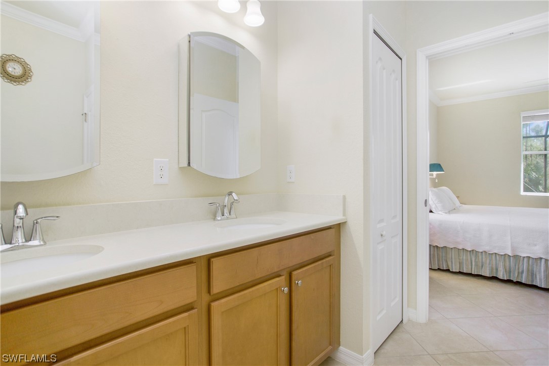 7948 Princeton Drive Naples, FL 34104 - Photo 16 of 35 a en suite bathroom with a double vanity sink and a mirror