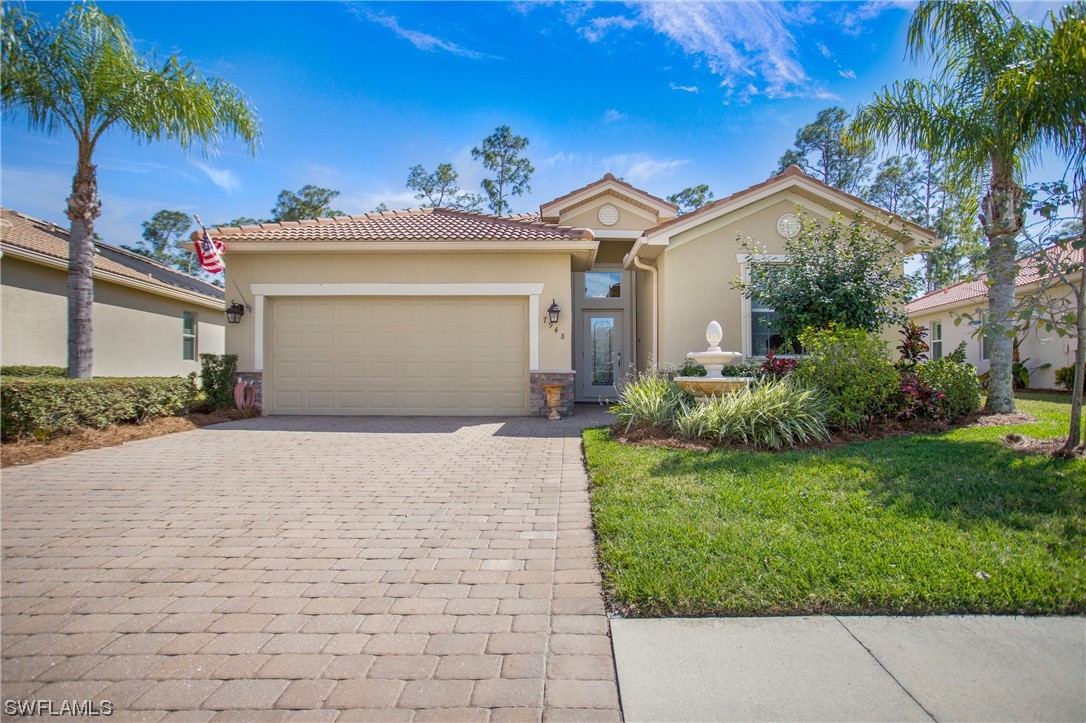 7948 Princeton Drive Naples, FL 34104 - Photo 2 of 35 a front view of a house with a garden
