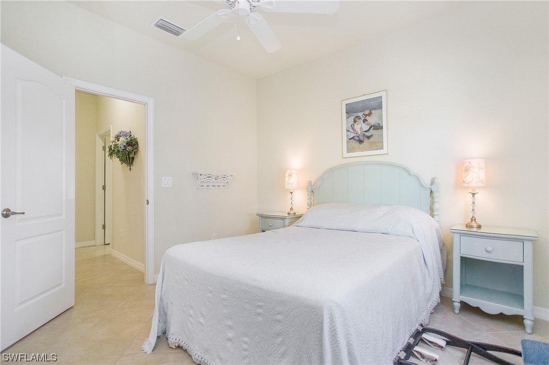 7948 Princeton Drive Naples, FL 34104 - Photo 21 of 35 a bedroom with a bed and a lamp