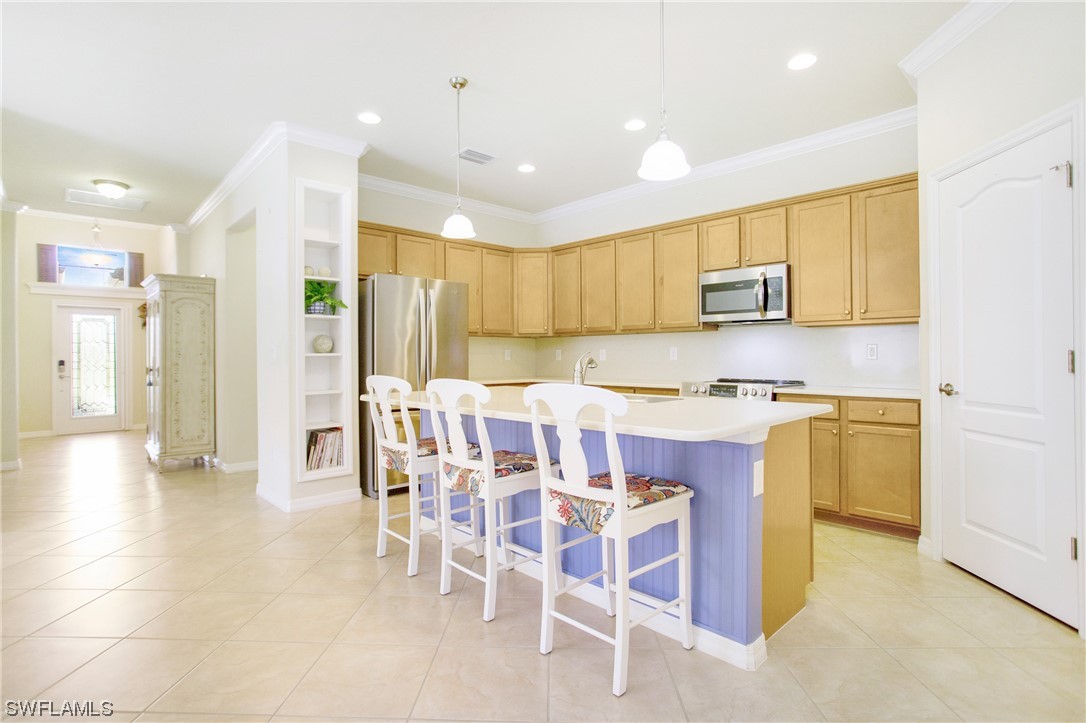 7948 Princeton Drive Naples, FL 34104 - Photo 3 of 35 a kitchen with a dining table chairs refrigerator and cabinets