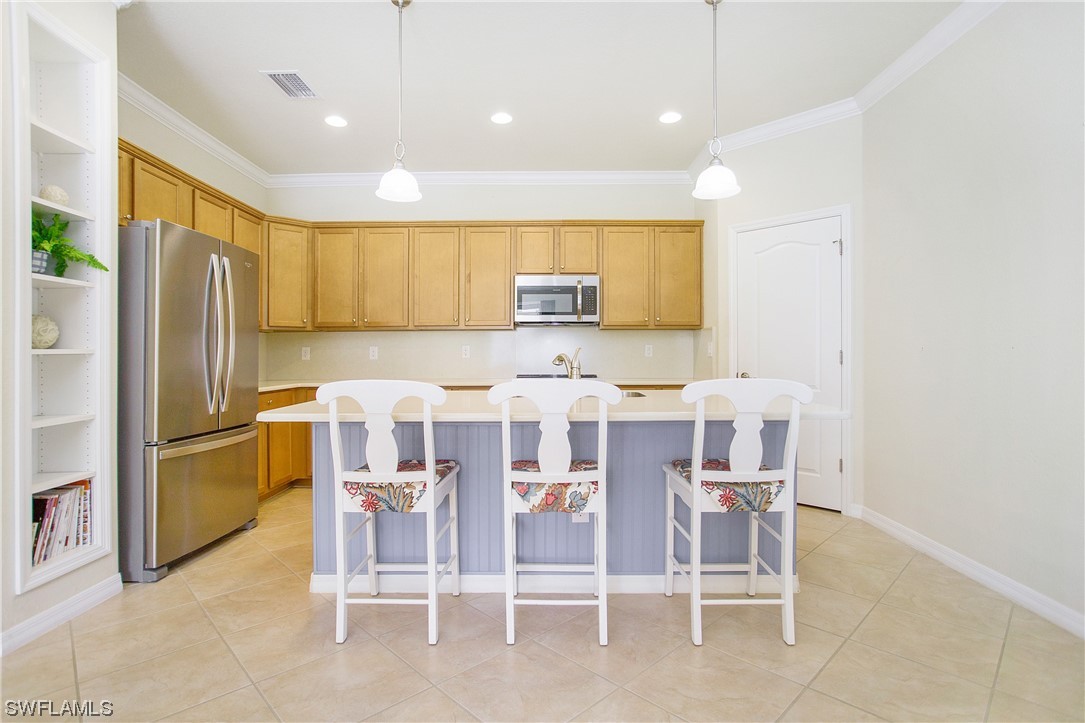 7948 Princeton Drive Naples, FL 34104 - Photo 4 of 35 a kitchen with stainless steel appliances kitchen island granite countertop a refrigerator and chairs