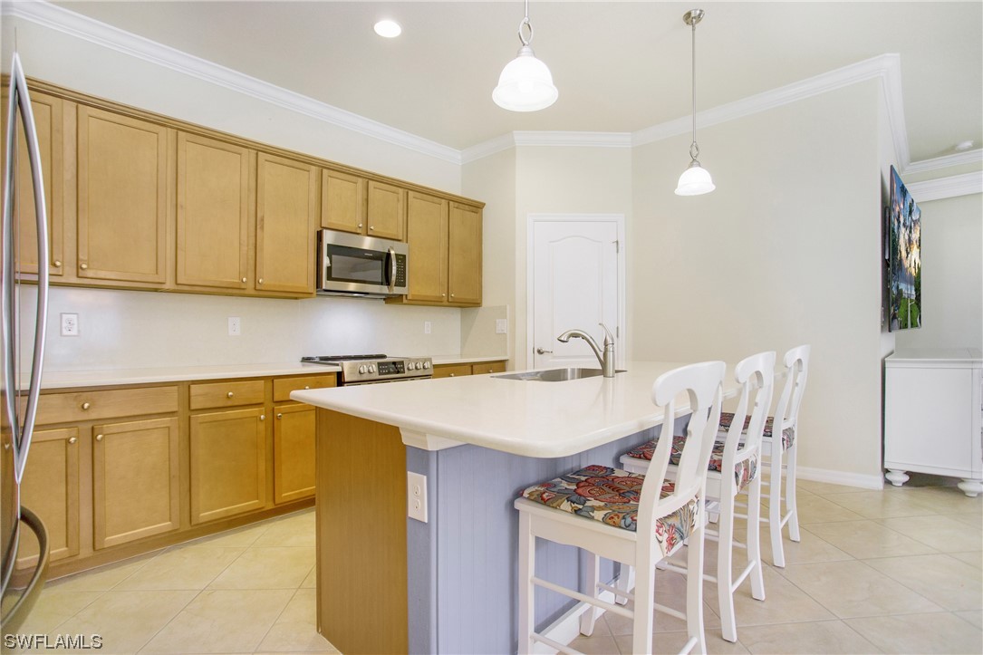 7948 Princeton Drive Naples, FL 34104 - Photo 5 of 35 a kitchen with a sink cabinets and wooden floor