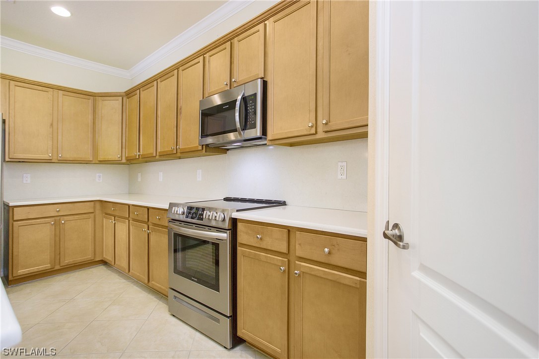 7948 Princeton Drive Naples, FL 34104 - Photo 6 of 35 a kitchen with stainless steel appliances granite countertop white cabinets stove a sink and dishwasher