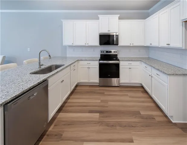 a kitchen with granite countertop a sink and a stove top oven