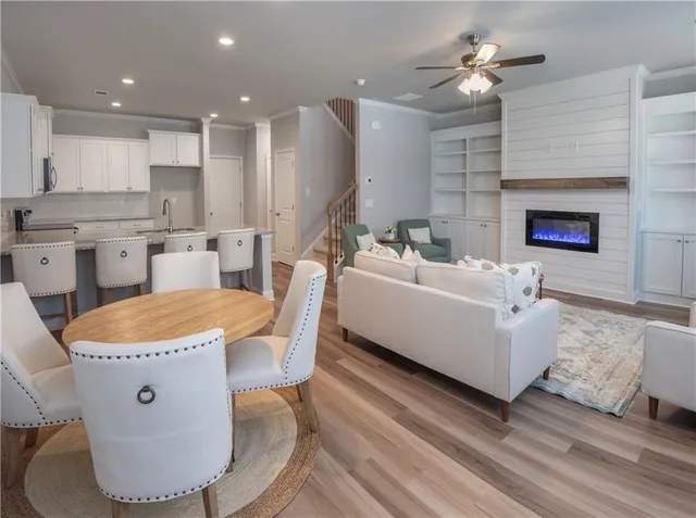 a living room with stainless steel appliances furniture a fireplace and a open kitchen view