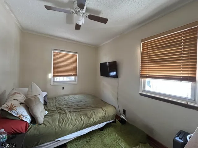 a bedroom with a bed and windows