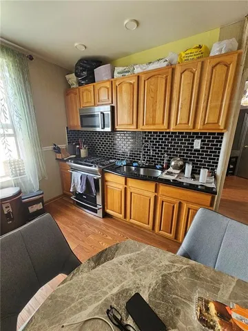 a kitchen with granite countertop a stove and a wooden cabinets