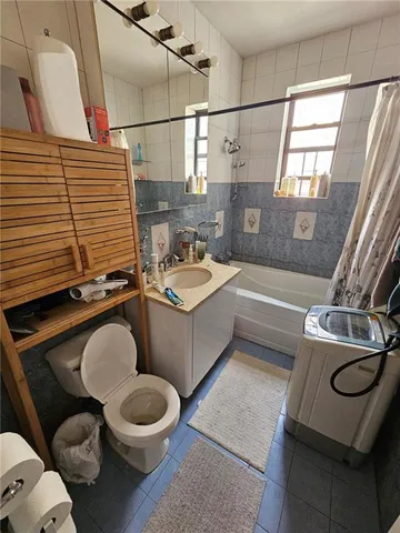 a bathroom with a granite countertop toilet sink and mirror