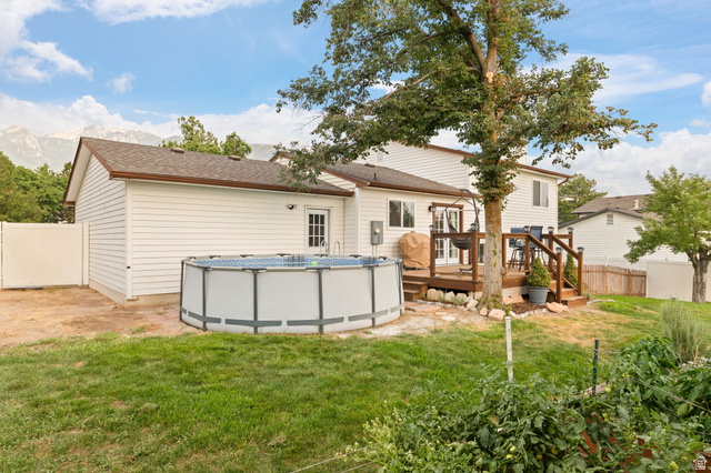 12152 Cinnamon Ridge Road Sandy, UT 84094 - Photo 36 of 51 Expansive backyard featuring a multi-level wood deck, white vinyl siding, and a fenced perimeter