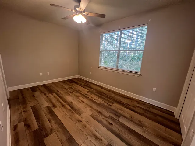 a view of a livingroom with a ceiling fan and window