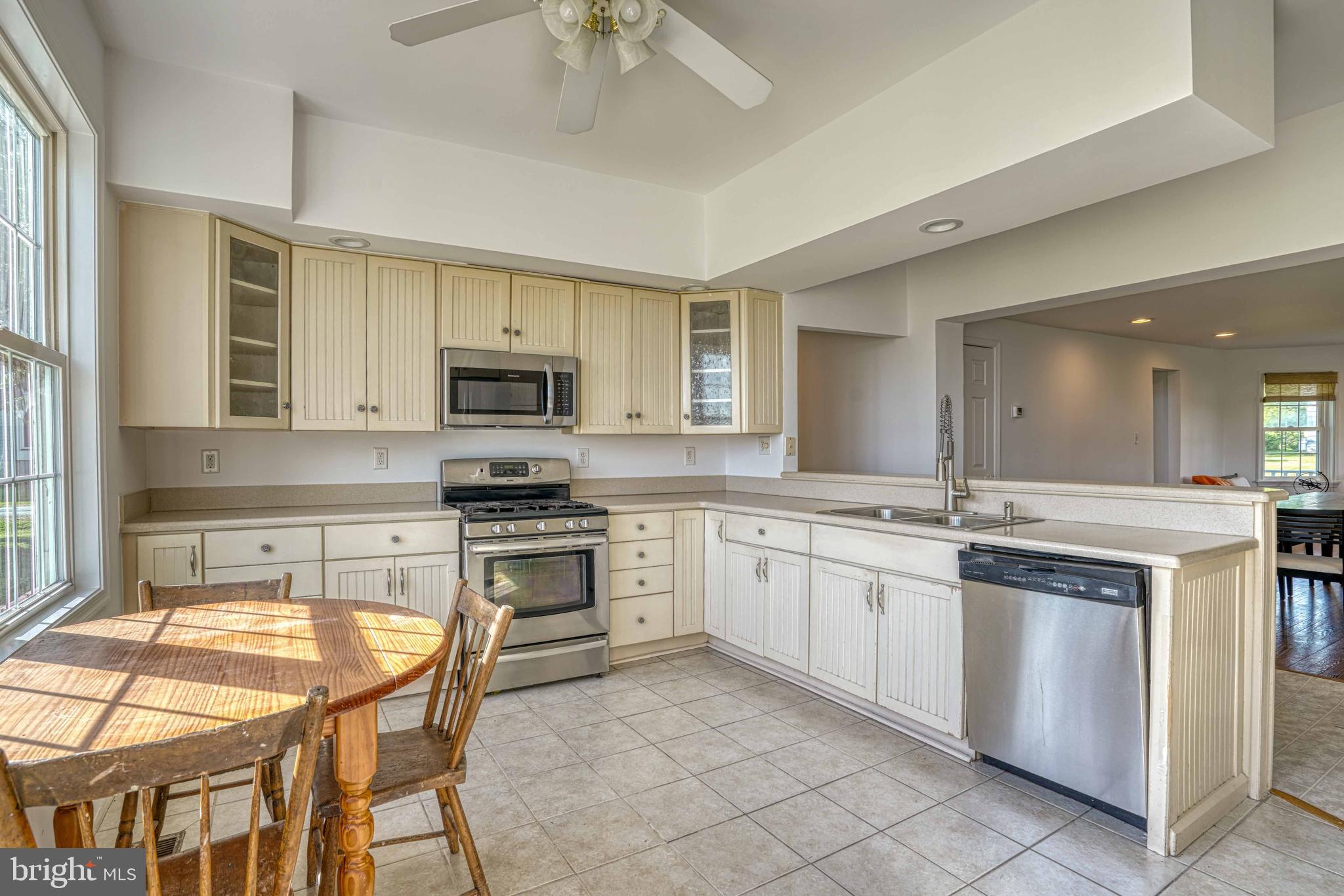 6403 Bozman Neavitt Road Neavitt, MD 21652 - Photo 10 of 31 a kitchen with stainless steel appliances granite countertop a stove top oven a sink dishwasher a dining table and chairs with wooden floor