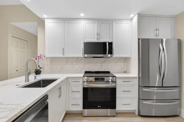 a kitchen with a refrigerator stove and wooden cabinets
