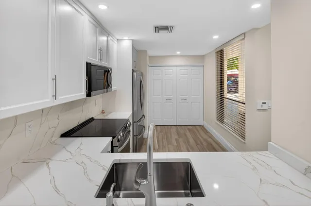 a kitchen with a sink stainless steel appliances and cabinets