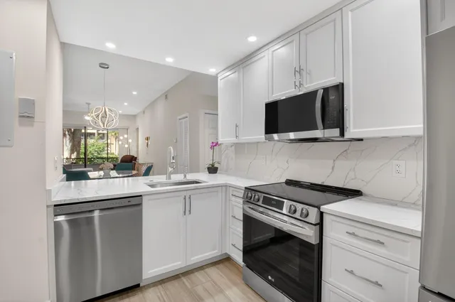 a view of counter top a sink and dishwasher with wooden floor