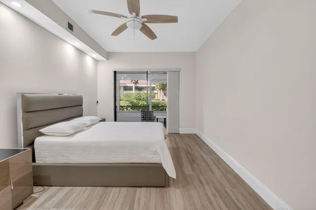 a bedroom with a large bed and wooden floor