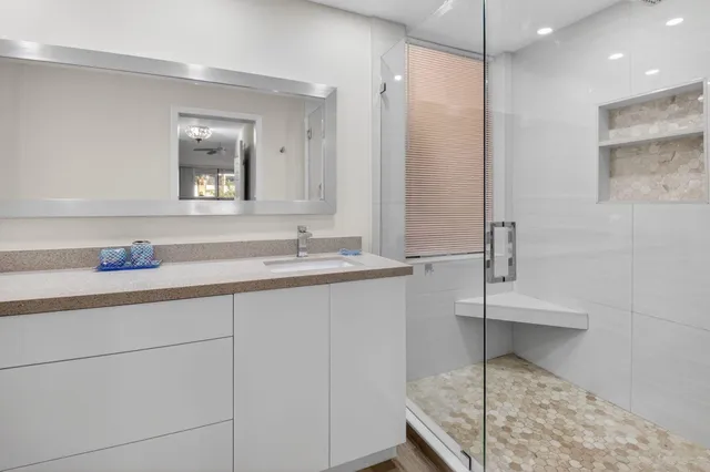 a bathroom with a granite countertop sink a toilet and shower
