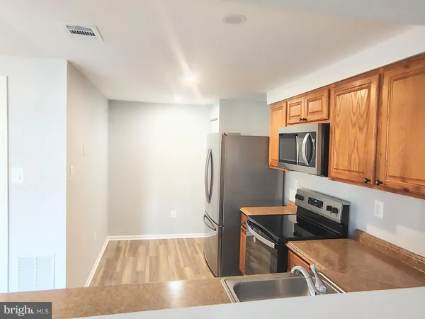 a kitchen with stainless steel appliances granite countertop a refrigerator and a sink