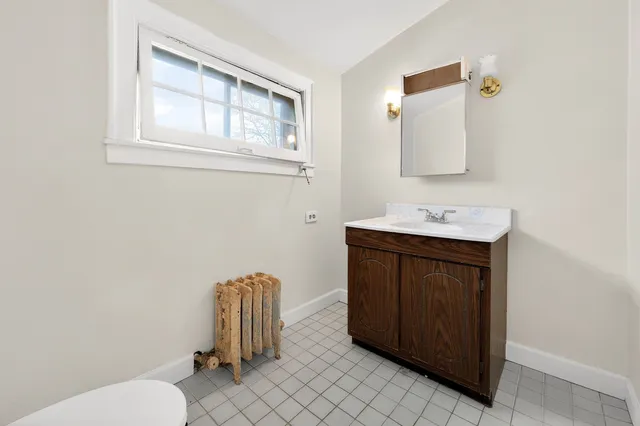 a bathroom with a sink vanity mirror and toilet