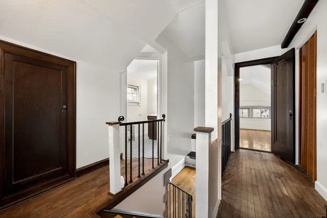 a view of a hallway with wooden floor and stairs