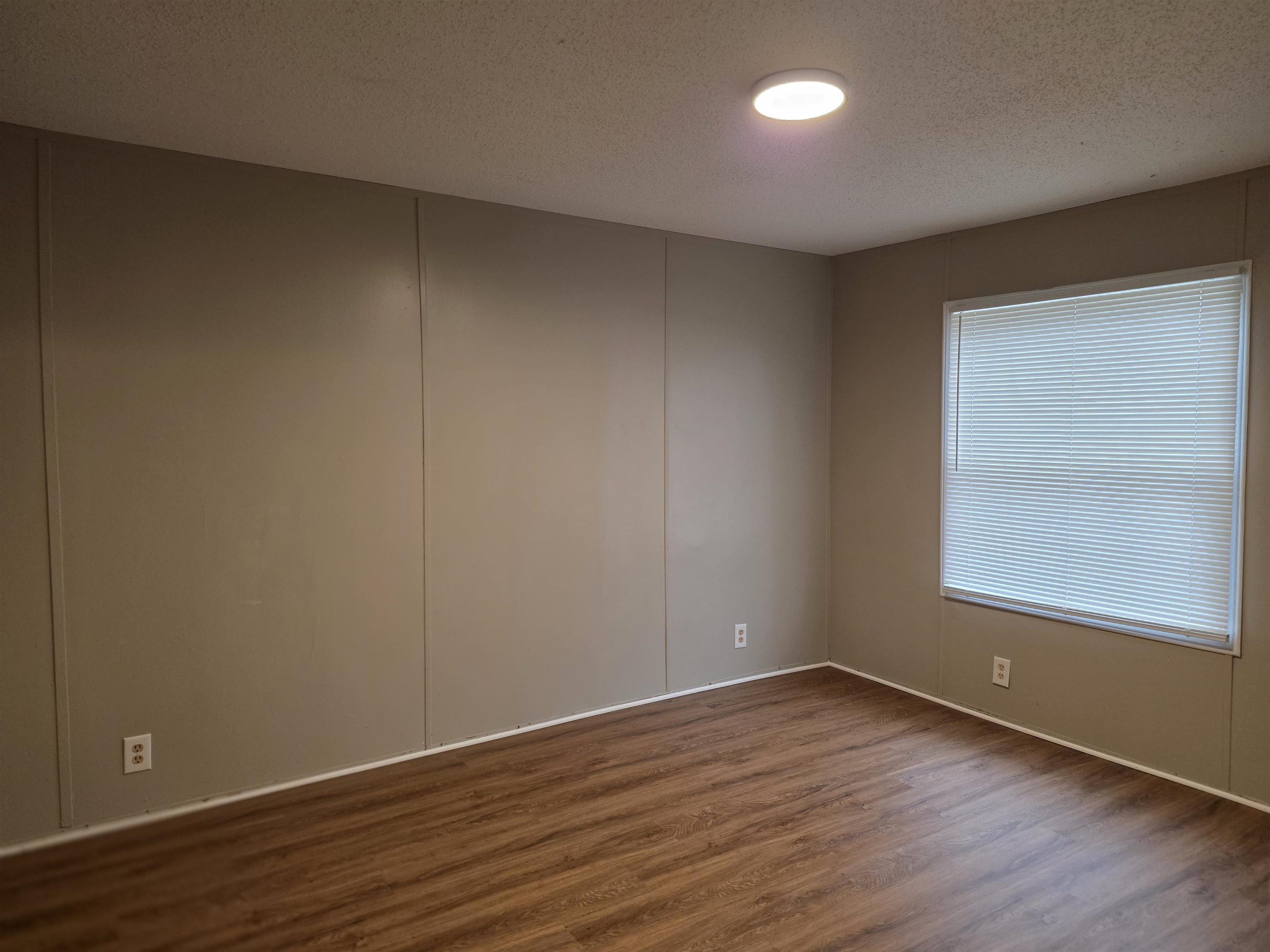2956 Lake Park Road Memphis, TN 38127 - Photo 5 of 25 a view of an empty room with wooden floor and a window