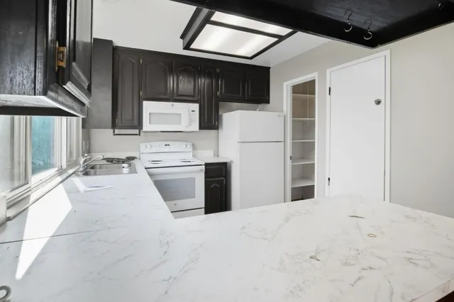 a kitchen with a refrigerator sink and cabinets