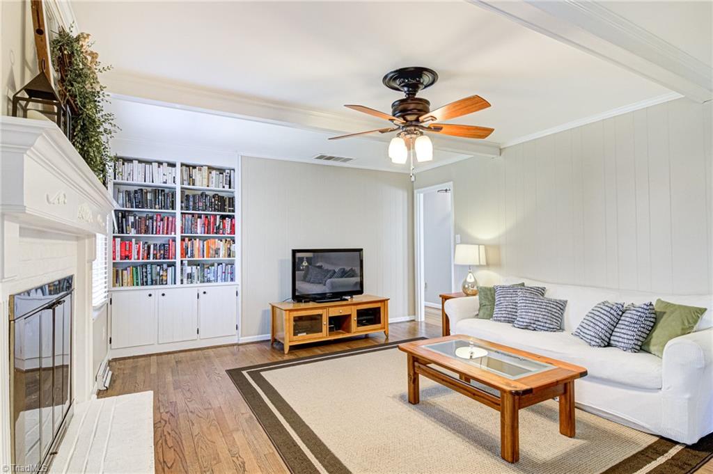 4516 Tower Road Greensboro, NC 27410 - Photo 14 of 26 Den is equipped with ceiling fan, built-in cabinetry and original pegged hardwood floors