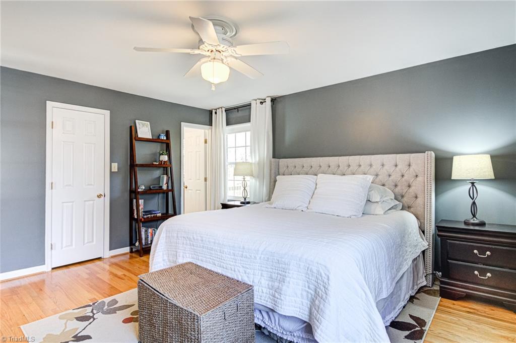 4516 Tower Road Greensboro, NC 27410 - Photo 17 of 26 Main/primary bedroom with walk-in closet, original hardwood floors and ceiling fan