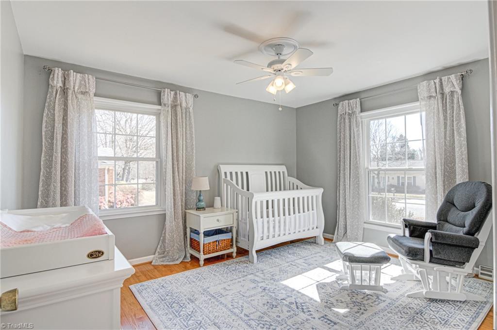 4516 Tower Road Greensboro, NC 27410 - Photo 20 of 26 Bedroom 3 is also appointed with original hardwood floors, neutral paint and ceiling fan