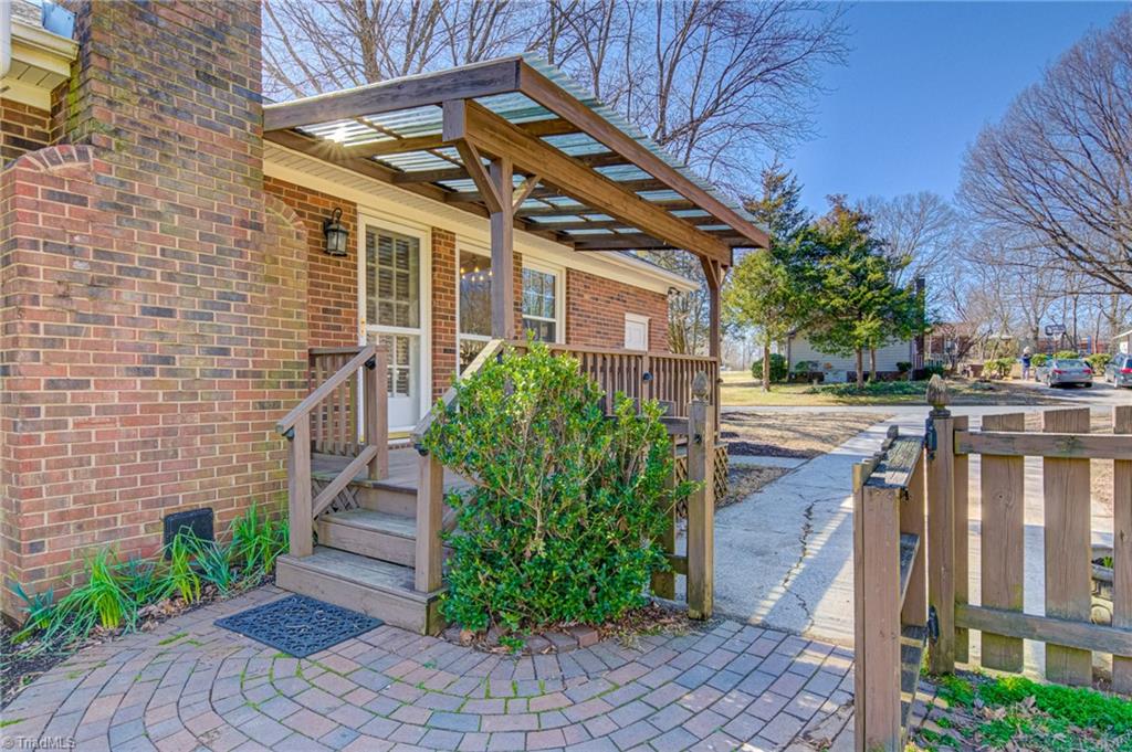 4516 Tower Road Greensboro, NC 27410 - Photo 23 of 26 Brick paver walkway connects this covered deck to driveway
