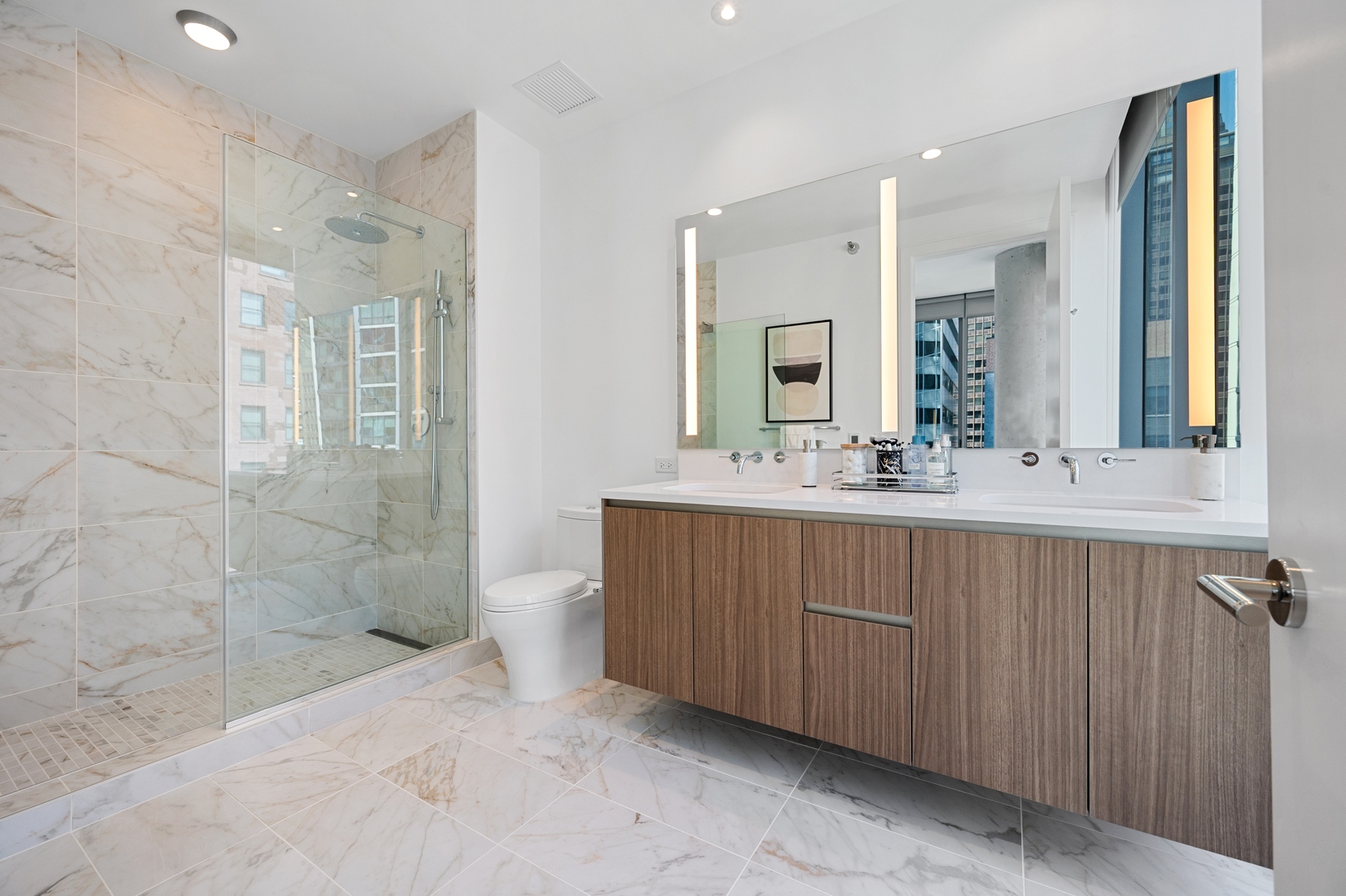 60 East Randolph Street, Unit 20D Chicago, IL 60601 - Photo 10 of 24 a bathroom with double vanity sink and a mirror