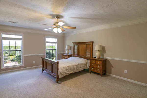 an empty room with windows and fan