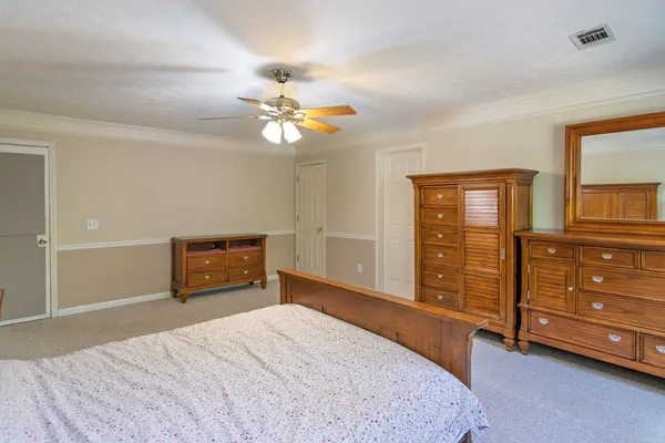 a bedroom with a bed chandelier and a window
