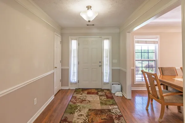 a view of a dining room with furniture a chandelier and wooden floor